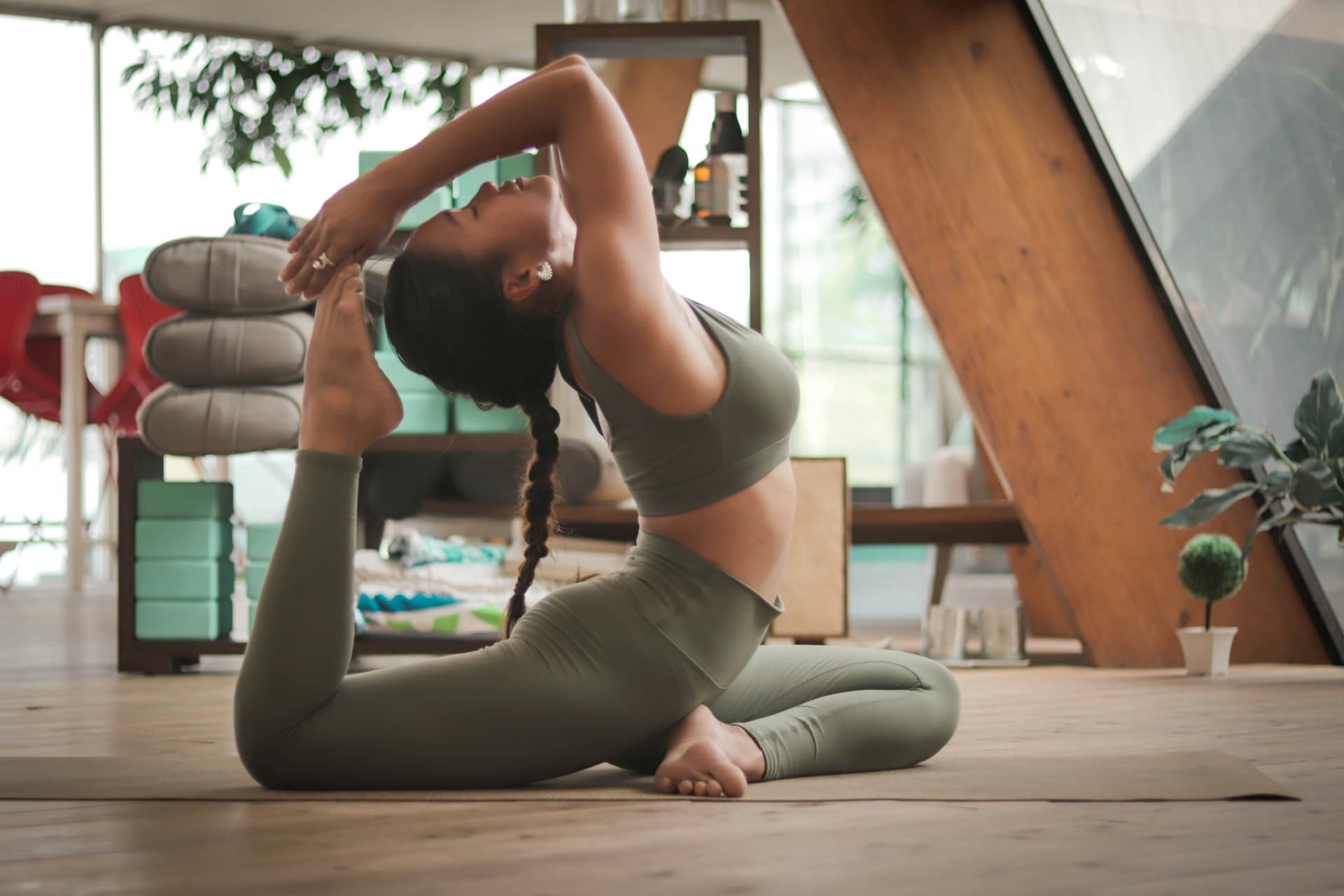 Woman in a deep backbend on a mat in a sunlit studio